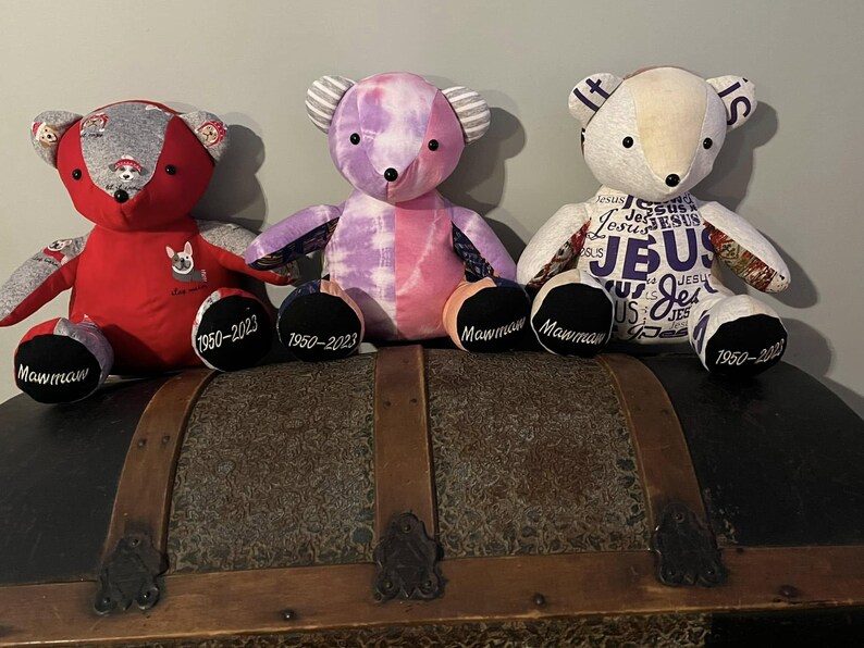 Peut inclure: Trois ours en peluche faits &agrave; la main avec des motifs et des couleurs uniques. L'un est rouge avec un tissu sur le th&egrave;me des chiens, un autre est tie-dye, et le troisi&egrave;me pr&eacute;sente le mot "JESUS". Chaque ours a "Mawmaw" et des dates brod&eacute;es sur les pieds.