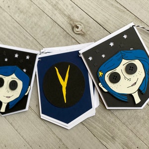 May include: A black and white banner with a blue-haired girl with large black buttons for eyes. The banner has a black circle with a yellow "Y" in the center. The banner is decorated with white stars.