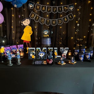 May include: A birthday party table decorated with a black and white "Happy Birthday" banner, black and purple balloons, and a black tablecloth. The table is decorated with a cake, cupcakes, and other treats. The theme of the party is "Coraline", a children's book and movie. The cake is decorated with a picture of Coraline, and the cupcakes are decorated with pictures of Coraline and other characters from the book.