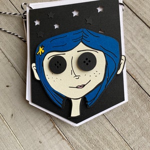 May include: A black and white banner with a cutout of a girl with blue hair and large black eyes. The banner has a star pattern and is decorated with a yellow star on the girl's hair.