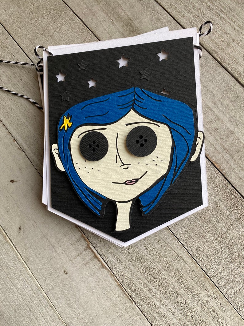 May include: A black and white banner with a cutout of a girl with blue hair and large black eyes. The banner has a star pattern and is decorated with a yellow star on the girl's hair.