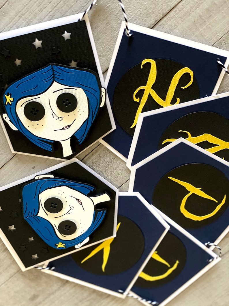 May include: A blue and black banner with a character from the movie "Coraline" and gold letters spelling out the word "N-I-G-H-T".