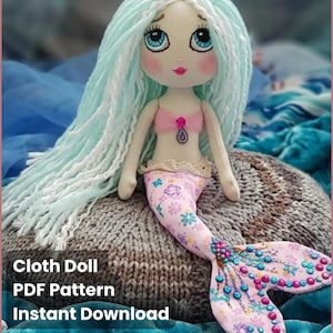 Puede incluir: Muñeca de tela con temática de sirena, con pelo largo de hilo azul claro, un top rosa y una cola estampada floral. Se lee "Sea Melody" y "Cloth Doll PDF Pattern Instant Download".