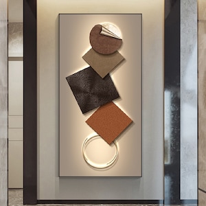 以下が含まれることがあります： 茶色、ベージュ、黒の幾何学模様が特徴の抽象的な壁画。 形状は重ねられ、重なり合って、ダイナミックでモダンな外観を作り出しています。 デザインにゴールドのリングが組み込まれており、エレガントさを加えています。