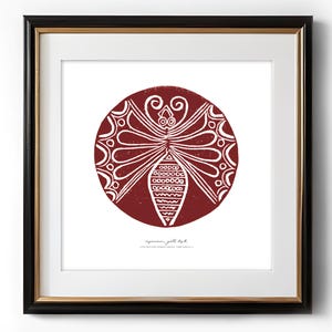 May include: A framed print of a red circle with a white butterfly design. The butterfly has intricate details and is surrounded by a decorative border. The text "agapanthus, jill tosh" is printed below the circle.