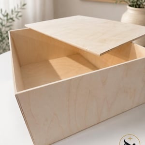 May include: A square, light-colored wooden box with a removable flat lid. The box is constructed from thin plywood sheets with visible natural wood grain patterns. A small logo featuring a bird and the text Little Bird Studio is in the corner.