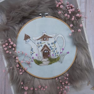 Può includere: Una tazza di ceramica bianca con manico nero e la scritta "But First, Coffee" in grassetto nero. La tazza è appoggiata su una superficie di legno. La tazza è alta circa 10 cm.