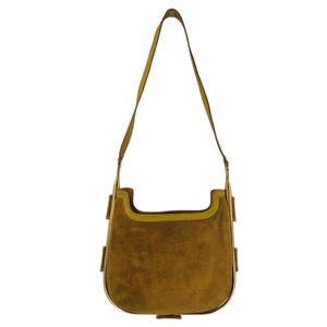 May include: A brown suede shoulder bag with a gold-tone frame and a long strap. The bag has a flap closure and a small pocket on the front.