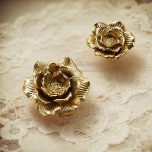 May include: A set of three ceramic mugs with a speckled, matte finish. The mugs are in shades of cream, light gray, and dark gray. Each mug has a simple, minimalist design and a rounded handle.