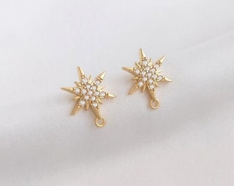 May include: A pair of gold-tone star-shaped earring charms with clear crystal accents. Each charm has a loop for attaching to jewelry.
