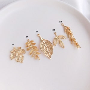 May include: Ten gold-colored metal leaf charms, each with a different design. The charms are numbered 1 through 5, with each number appearing twice.