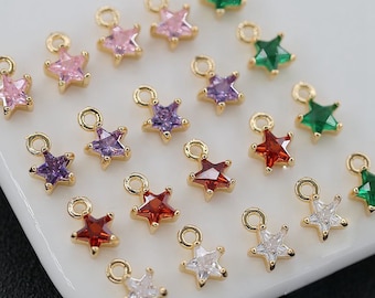 May include: Assortment of gold star-shaped charms with various colored rhinestones. The charms have a loop at the top for attaching to jewelry or other crafts.