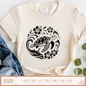 May include: Cream-colored t-shirt featuring a black turtle design within a circular floral and wave pattern. The turtle has a detailed shell and is surrounded by hibiscus flowers. The shirt is made of a soft material.