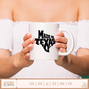 May include: White ceramic mug with a black graphic of the state of Texas and the words "MADE IN TEXAS". The mug has a curved handle and is held by a person.