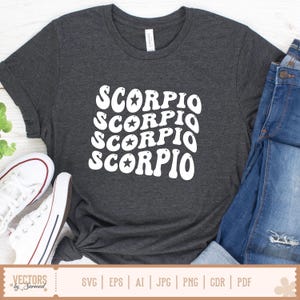 Op de afbeelding: Donkergrijs t-shirt met het woord "SCORPIO" in wit, vier keer gestapeld, elk met een ster. Het shirt wordt gecombineerd met een blauwe jeans en witte sneakers. Het t-shirt is gemaakt van een zacht materiaal.