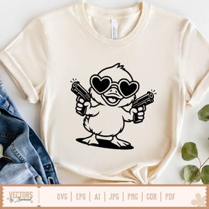 K&ouml;nnte beinhalten: Cremefarbenes T-Shirt mit einer schwarzen Grafik einer Ente mit herzf&ouml;rmiger Sonnenbrille, die zwei Pistolen h&auml;lt. Das Shirt hat einen klassischen Rundhalsausschnitt und kurze &Auml;rmel. Der untere Teil des Shirts hat eine Grafik mit Dateitypoptionen.