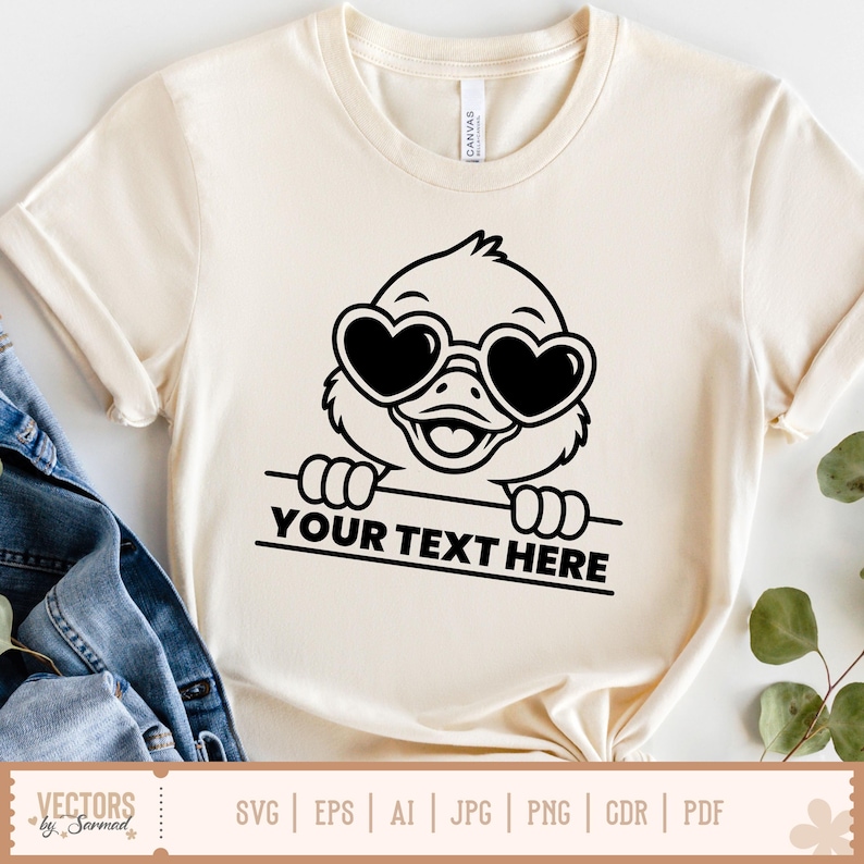 K&ouml;nnte beinhalten: Cremefarbenes T-Shirt mit einer schwarzen Cartoon-Ente, die eine herzf&ouml;rmige Sonnenbrille tr&auml;gt. Die Ente h&auml;lt ein Banner mit dem Text "YOUR TEXT HERE". Das Shirt hat kurze &Auml;rmel und einen Rundhalsausschnitt.