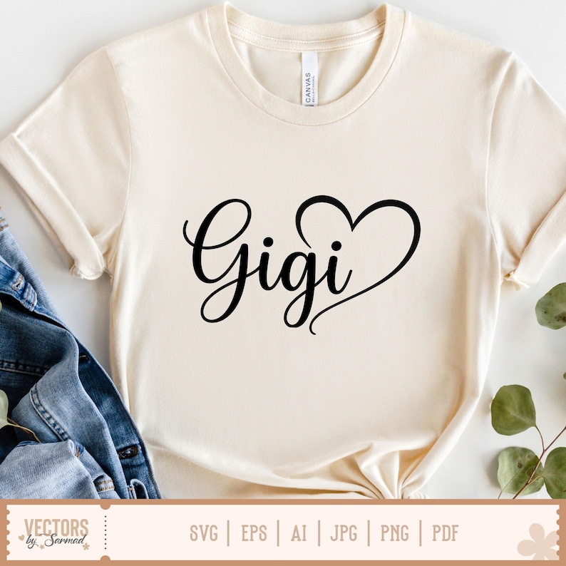 Pu&ograve; includere: T-shirt color crema con la scritta "Gigi" in nero, in corsivo, con un cuore integrato nel design. La maglietta &egrave; realizzata in un materiale morbido e ha maniche corte. Il fondo della maglietta &egrave; annodato.