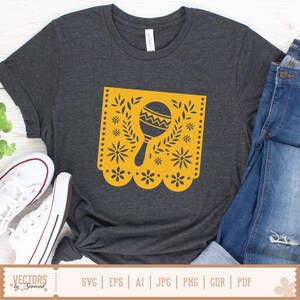 May include: Charcoal grey t-shirt with a yellow maraca design in a floral frame. The maraca has a zigzag pattern. The shirt is styled with blue jeans and white trainers. The text "VECTORS by Sarmad" is at the bottom of the image.