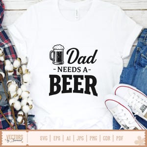 May include: White t-shirt with the text "Dad Needs a Beer" in black, accompanied by a beer mug graphic. The shirt is displayed with blue jeans and white sneakers. The bottom of the image shows file type options.