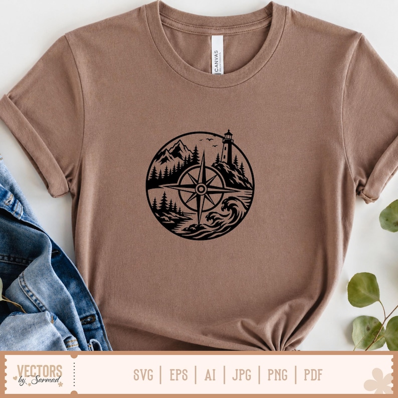 以下が含まれることがあります： 茶色のクルーネックTシャツで、黒い円形のグラフィックプリントが施されています。デザインは、灯台、山、松の木、海の波を含む風景の中に配置されたコンパスローズを描いています。Tシャツは標準的な半袖のカットです。