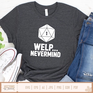 May include: Charcoal grey t-shirt with a white geometric die graphic, displaying the number 1, and the words "WELP... NEVERMIND". The image includes blue jeans and white trainers, suggesting a relaxed, casual outfit. The design is likely aimed at gamers or those with a humorous outlook.