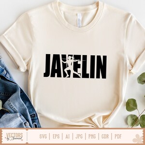 Puede incluir: Camiseta color crema con la palabra "JAVELIN" en letras negras y audaces. Una silueta blanca de un lanzador de jabalina est&aacute; integrada en el dise&ntilde;o. La camiseta tiene cuello redondo y mangas cortas.