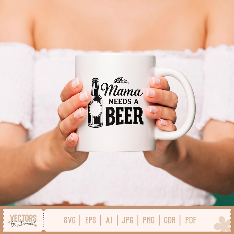 May include: White ceramic mug with the text "Mama needs a beer" in black. The design includes a beer bottle illustration and wheat. The mug is held by a person wearing a white off-the-shoulder top.
