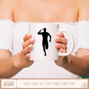 Puede incluir: Taza de cer&aacute;mica blanca con una silueta negra de un lanzador de jabalina. La taza tiene un asa curva y la sostiene una persona. La taza es de tama&ntilde;o est&aacute;ndar para caf&eacute; o t&eacute;.