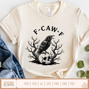 May include: Cream-colored t-shirt with the text "F-CAW-F" above a black illustration of a crow perched on a skull, surrounded by bare tree branches. The shirt has short sleeves and a round neckline. The bottom of the shirt shows file type icons.