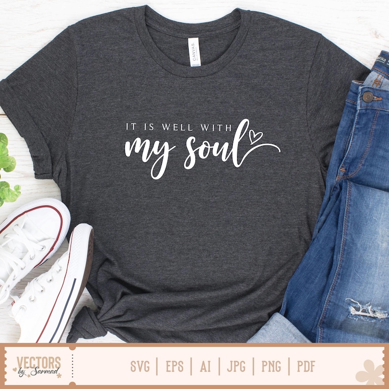 Puede incluir: Camiseta gris oscuro con la frase "IT IS WELL WITH my soul" en escritura blanca. La camiseta se combina con vaqueros azules y zapatillas blancas. La camiseta est&aacute; hecha de un material suave.