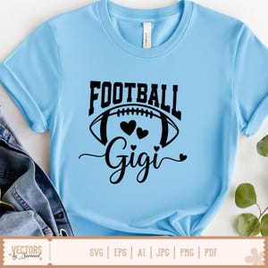 Pu&ograve; includere: T-shirt azzurra con la scritta "FOOTBALL" sopra una grafica di football americano con due cuori e il nome "Gigi" in corsivo. La maglietta ha le maniche arrotolate ed &egrave; realizzata in un materiale morbido.