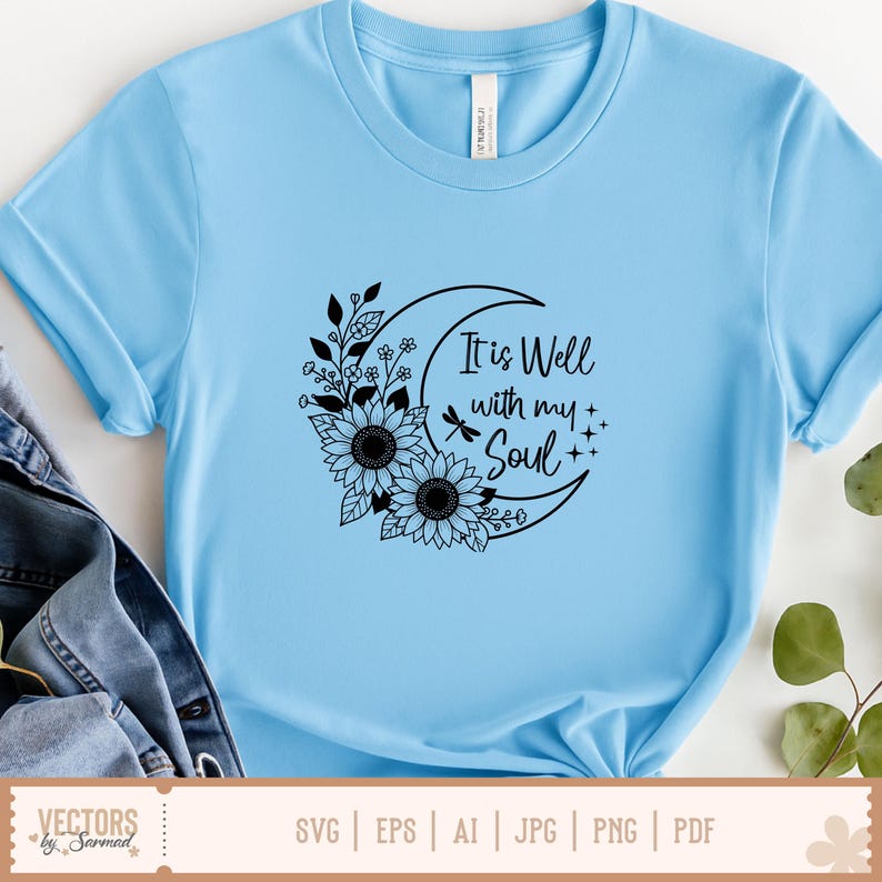 Puede incluir: Camiseta azul claro con un dise&ntilde;o gr&aacute;fico negro. El dise&ntilde;o presenta una luna creciente, girasoles y el texto "It is Well with my Soul". La camiseta es de material suave.