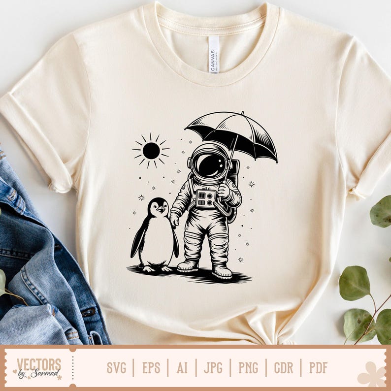 May include: Cream-colored t-shirt featuring a black and white illustration of an astronaut holding an umbrella, walking with a penguin. A sun graphic is in the background. The shirt has a crew neck and short sleeves. The bottom of the shirt has the text "VECTORS by Sarmad".