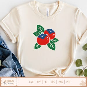 May include: Cream-colored t-shirt featuring a graphic of two red berries with blue tops and green leaves. The shirt has short sleeves and a round neckline. The bottom of the shirt displays the text "VECTORS by Sarmad" and file type options.