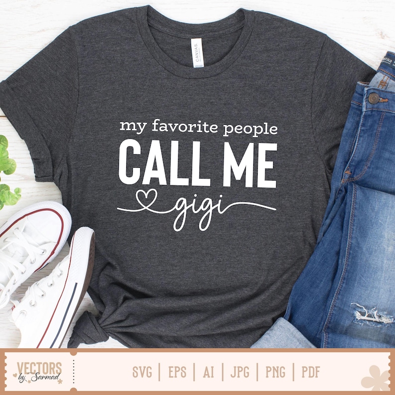 Pu&ograve; includere: T-shirt grigio scuro con la scritta bianca "my favorite people CALL ME gigi". Il design include un simbolo a forma di cuore. L'immagine mostra anche jeans blu e scarpe da ginnastica bianche. La parte inferiore dell'immagine mostra il testo "VECTORS by Sarmad" e le opzioni del tipo di file.