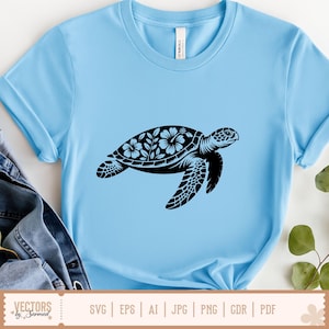May include: Light blue t-shirt featuring a black sea turtle design. The turtle's shell is decorated with floral patterns. The shirt is made of a soft material and is suitable for casual wear. The bottom of the image shows the text "VECTORS by Sarmad" and file type options.