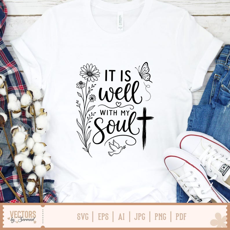 Puede incluir: Camiseta blanca con la frase "IT IS well WITH MY SOUL" en escritura negra, acompa&ntilde;ada de gr&aacute;ficos florales y una cruz. La camiseta se muestra con vaqueros azules y zapatillas blancas.