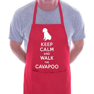 Puede incluir: Delantal rojo con una silueta blanca de un perro y el texto "Keep Calm and Walk the Cavapoo".