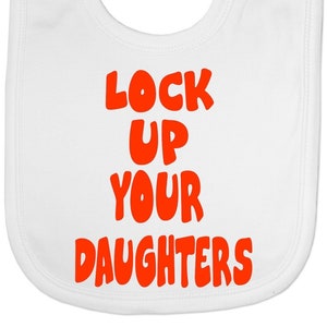 May include: White baby bib featuring the phrase "LOCK UP YOUR DAUGHTERS" in vibrant orange, rounded letters. The bib is designed to protect clothing during mealtimes, with a curved shape and a neck opening.
