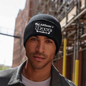 May include: A black beanie with a white patch that reads "What A Difference a Dave Makes" with two thumbs up symbols.