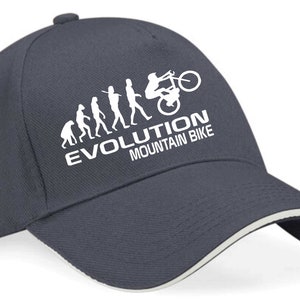 May include: A navy blue baseball cap with a white evolution of man graphic, ending with a person riding a mountain bike. The text "EVOLUTION MOUNTAIN BIKE" is printed below the graphic.