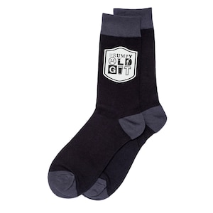 May include: A pair of black socks with gray accents at the toe, heel, and cuff. A white shield graphic displays the words "GRUMPY OLD GIT" with related icons. The socks are made of a soft, comfortable material.