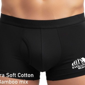 May include: Black boxer briefs featuring a wide elastic waistband with the word ALPHA embossed. The right leg displays a white graphic showing the evolution of rugby with a dragon and the text EVOLUTION WELSH RUGBY. Ultra Soft Cotton Bamboo mix.