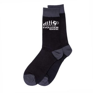 May include: A pair of black socks with gray accents on the toe and cuff. The socks feature a white graphic of the evolution of mountain biking with the text "EVOLUTION MOUNTAIN BIKE".