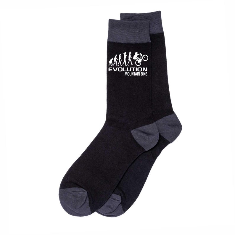 May include: A pair of black socks with gray accents on the toe and cuff. The socks feature a white graphic of the evolution of mountain biking with the text "EVOLUTION MOUNTAIN BIKE".