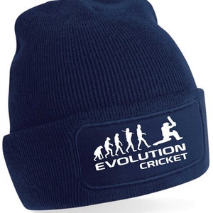 May include: A navy blue beanie with a white patch featuring a stick figure evolution of a cricket player. The patch reads "Evolution Cricket".