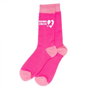 May include: A pair of pink socks with a white heart and the text "HOME Is Where Your Is" on one sock. The heart contains a silhouette of a dog.