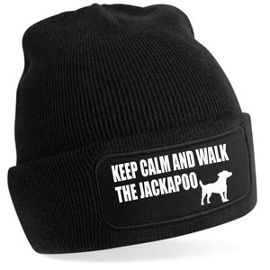 Może przedstawiać: Czarna czapka z dzianiny z białą naszywką z napisem "Keep Calm and Walk the Jackapoo" i sylwetką psa rasy Jackapoo.