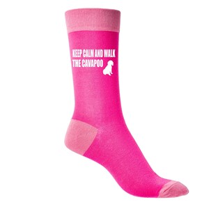 May include: Pink socks with a white silhouette of a dog and the text "Keep Calm and Walk the Cavapoo".